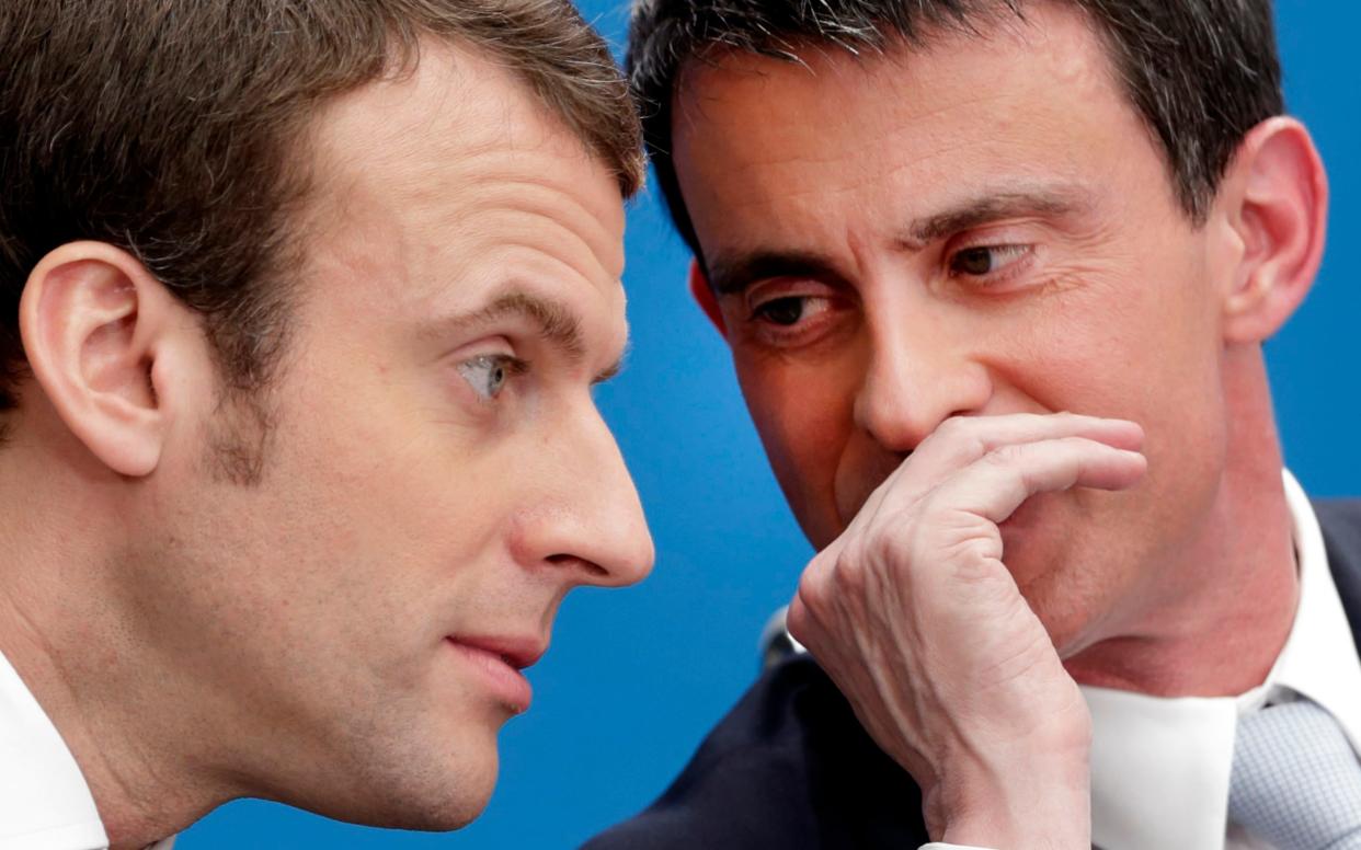 Then French prime minister Manuel Valls, right, speaks with then economy minister Emmanuel Macron - now favourite to become French president - Reuters