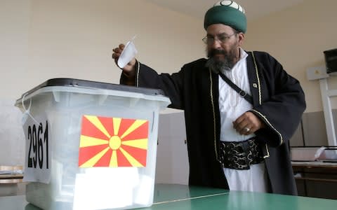 A Muslim cleric casts his ballot at polling station during the referendum in Skopje, Macedonia - Credit: Boris Grdanoski/AP