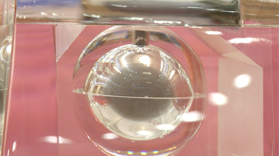 A spherical, transparent housing with grayish material inside.