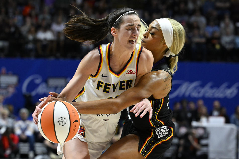 Connecticut Sun guard Dijonae Carrington (21) fouls Indiana Fever guard Kaitlin Clark (22) during the third quarter of a WNBA basketball game, Tuesday, May 14, 2024, in Uncasville, Conn. (AP Photo/Jessica Hale)