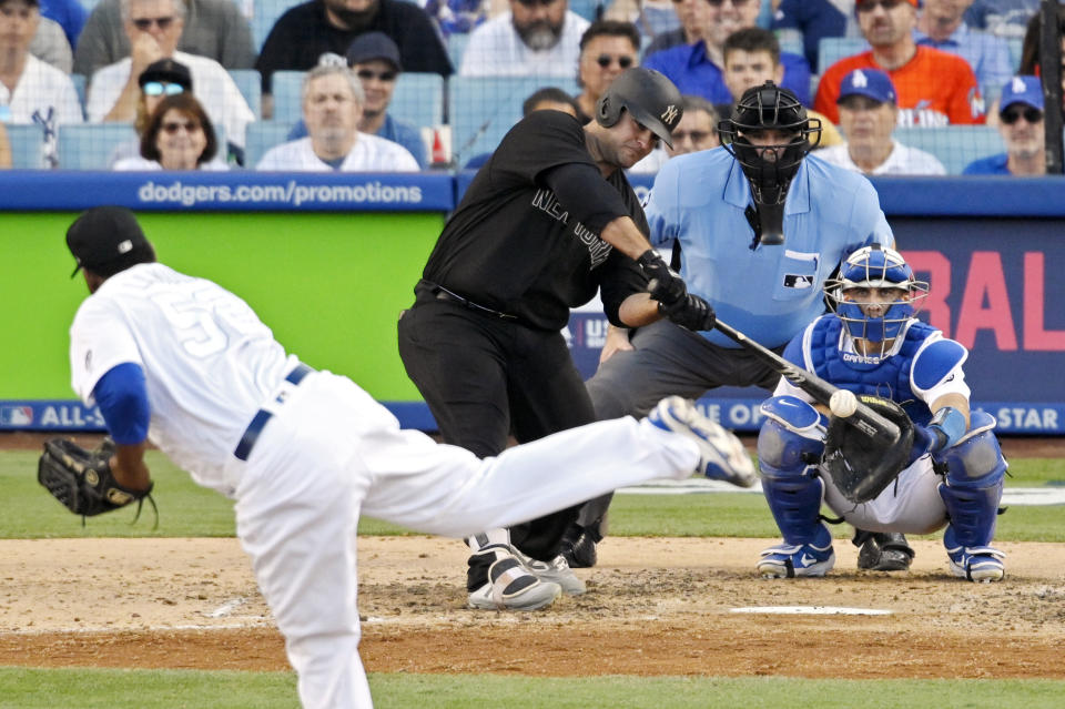 New York Yankees' Mike Ford hits an RBI double thrown from Los Angeles Dodgers relief pitcher Pedro Baez as catcher Austin Barnes, right, and home plate umpire Bill Welke watch during the eighth inning of a baseball game Sunday, Aug. 25, 2019, in Los Angeles. (AP Photo/Mark J. Terrill)