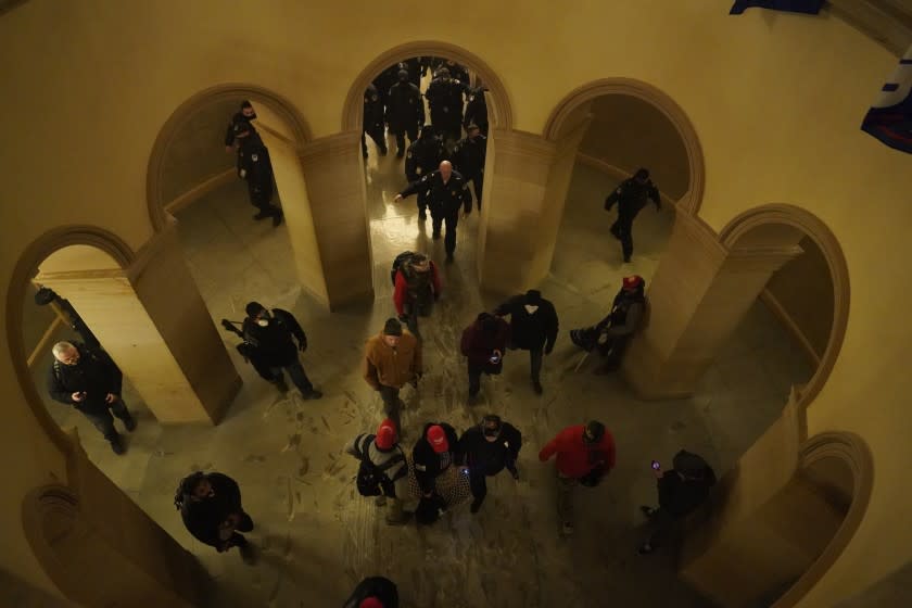 Protesters walk through the halls of the Capital building after forcing their way in