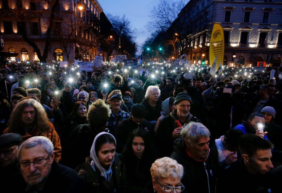 FILE - In this Thursday, March 15, 2018, file photo, people taking part in a march against Prime Minister Viktor Orban flash the lights of their mobile phones in Budapest, Hungary. With a campaign centered on stopping immigration, Hungary’s ruling Fidesz party is expected to continue its dominance in the European Parliament election at the end of May. While Hungary has been practically closed to immigrants from the Middle East, Asia and Africa since Prime Minister Viktor Orban had border fences built in 2015, he continues to warn voters about the threat of a “migrant invasion” that would put at risk Europe’s Christian culture. (AP Photo/Darko Vojinovic, File)