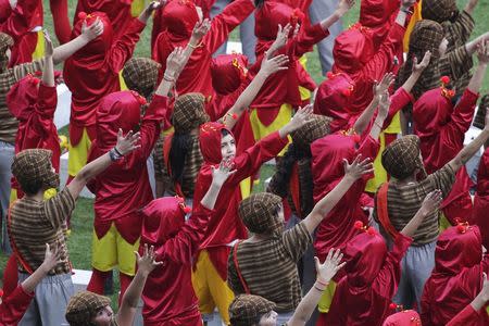 Children, dressed as "El Chapulin Colorado" and "El Chavo del 8', characters by late screenwriter Roberto Gomez Bolanos, perform at the end of a mass in memory of Bolanos at the Azteca stadium in Mexico City November 30, 2014. REUTERS/Tomas Bravo