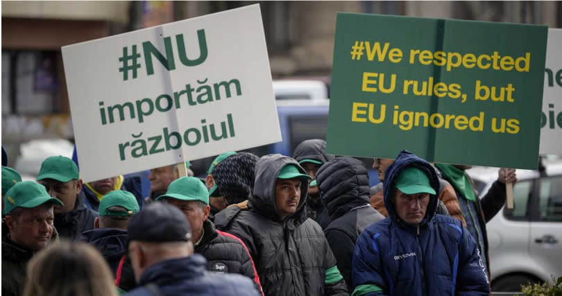 約200名農民在歐盟執委會駐布加勒斯特的總部舉牌示威，上面寫著：「我們尊重歐盟規則，但歐盟忽視了我們」。（圖／達志／美聯社）