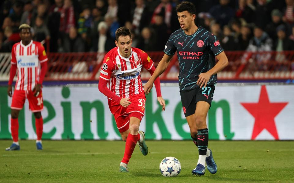 Matheus Nunes of Manchester City runs with the ball whilst under pressure from Srdjan Mijailovic of FK Crvena zvezda during the UEFA Champions League match between FK Crvena zvezda and Manchester City at Stadion Rajko MitiÄ‡ on December 13, 2023 in Belgrade, Serbia