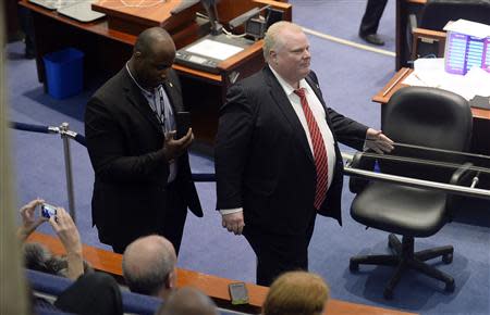 Toronto Mayor Rob Ford (R) walks around council chambers while an unidentified member of his staff captures images of the public gallery during a special council meeting at City Hall in Toronto November 18, 2013. REUTERS/Aaron Harris