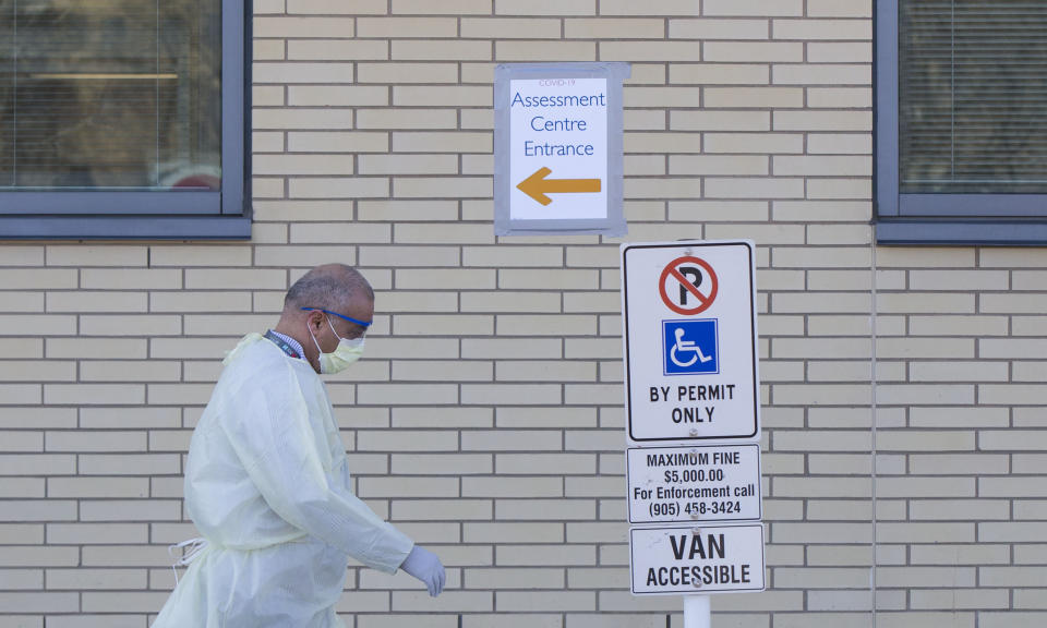BRAMPTON, March 15, 2020 -- A medical worker wearing protective gear walks past a direction sign of a COVID-19 assessment center at Peel Memorial Center for Integrated Health and Wellness in Brampton, Ontario, Canada, on March 15, 2020. Canada's Ontario provincial government reported 39 new cases of COVID-19 Sunday morning, increasing the provincial total to 142. (Photo by Zou Zheng/Xinhua via Getty) (Xinhua/Zou Zheng via Getty Images)