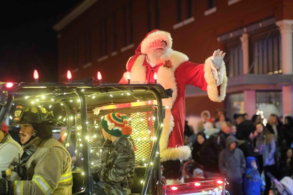 Santa Claus waves to the crowd from his ATV Saturday night at the Parade of Lights in Canyon.