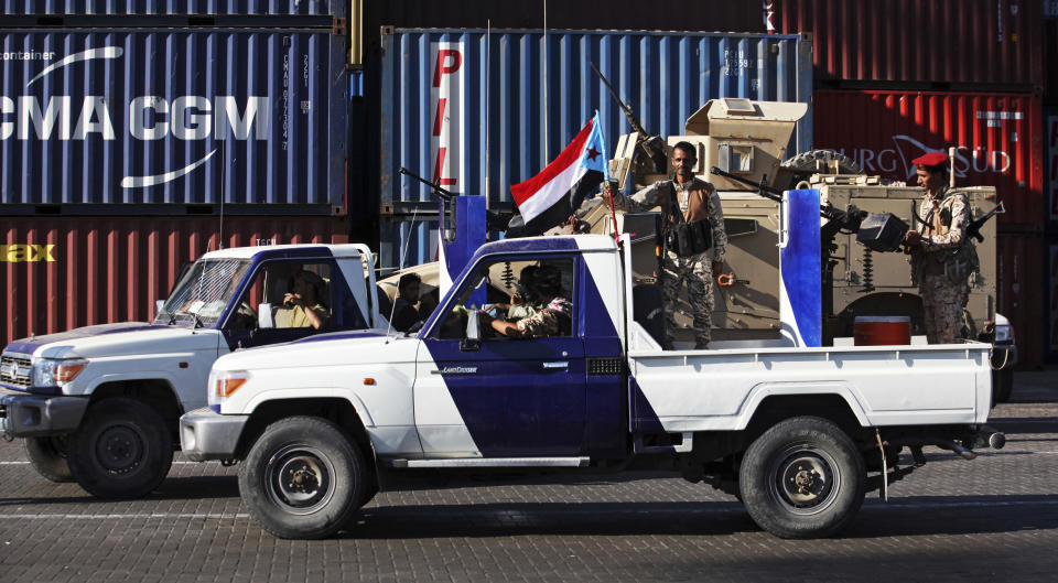 In this Wednesday, Dec. 12, 2018 photo, soldiers allied to Yemen's internationally recognized government fly the South Yemen flag at the port of Aden in Aden, Yemen. A sense of normalcy has returned to Aden, now the seat of power for Yemen's internationally recognized government, but many challenges remain for bringing a lasting peace to the Arab world's poorest country. Since Yemen's war broke out, secessionists wanting South Yemen to again break away have increasingly been flying the flag as a symbol of their aspiration. (AP Photo/Jon Gambrell)