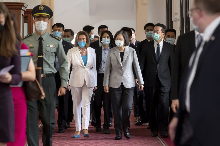 In this photo released by the Taiwan Presidential Office, U.S. House Speaker Nancy Pelosi, center left, and Taiwanese President President Tsai Ing-wen arrive for a meeting in Taipei, Taiwan, Wednesday, Aug. 3, 2022. U.S. House Speaker Nancy Pelosi, meeting top officials in Taiwan despite warnings from China, said Wednesday that she and other congressional leaders in a visiting delegation are showing they will not abandon their commitment to the self-governing island. (Taiwan Presidential Office via AP)