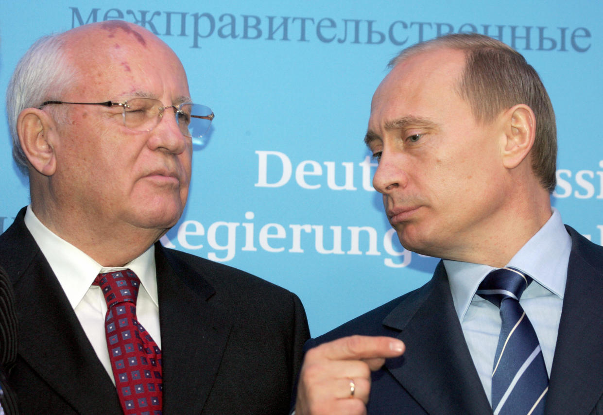 Russian President Vladimir Putin talks to former Soviet President Mikhail Gorbachev.