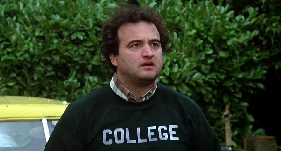 A man wearing a green "college" sweatshirt.