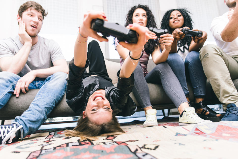 Four young adults playing console games.