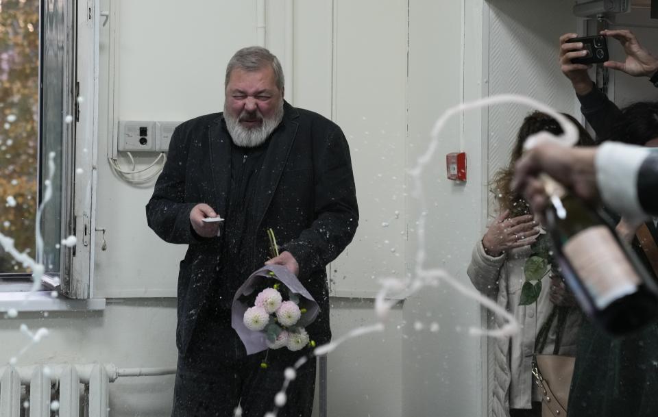 Colleagues pour champaign on Novaya Gazeta editor Dmitry Muratov at the Novaya Gazeta newspaper, in Moscow, Russia, Friday, Oct. 8, 2021. As a new Nobel Peace Prize laureate, Russian newspaper editor Dmitry Muratov has downplayed the buzz around his name. The award isn't for him, he says, but for all of the staff at Novaya Gazeta, the independent Russian newspaper noted for investigations of official corruption, human rights abuses and Kremlin criticism. (AP Photo/Alexander Zemlianichenko)