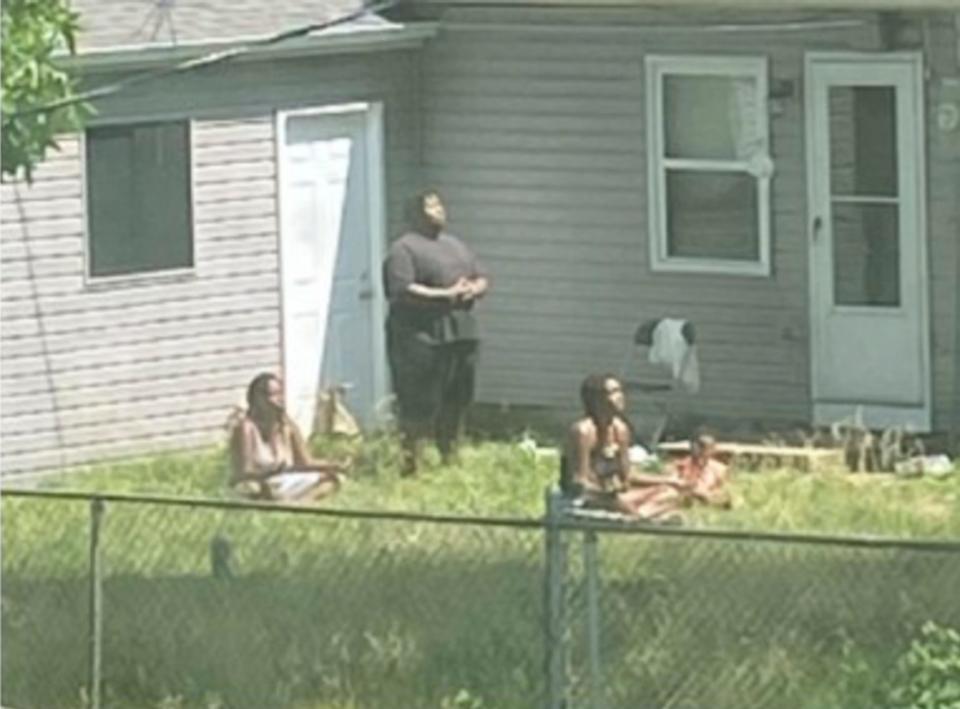 A neighbor provided this photo to police in Berkeley, Missouri, investigating the disappearance of the adults shown meditating in their backyard. Police say they are followers of a 'spiritual cult' and have been missing since August.