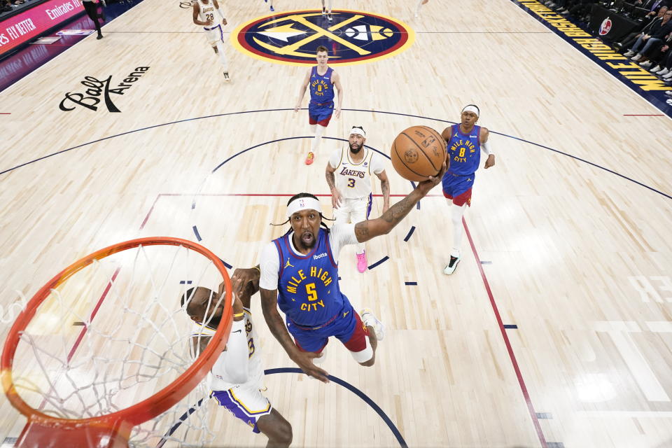 Denver Nuggets guard Kentavious Caldwell-Pope (5) goes up to shoot against Los Angeles Lakers forward LeBron James, left, during the first half in Game 1 of an NBA basketball first-round playoff series, Saturday, April 20, 2024, in Denver. (AP Photo/Jack Dempsey)