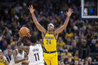 Indiana Pacers guard Buddy Hield (24) defends Brooklyn Nets guard Kyrie Irving (11) during the second half of an NBA basketball game in Indianapolis, Friday, Nov. 25, 2022. (AP Photo/Doug McSchooler)