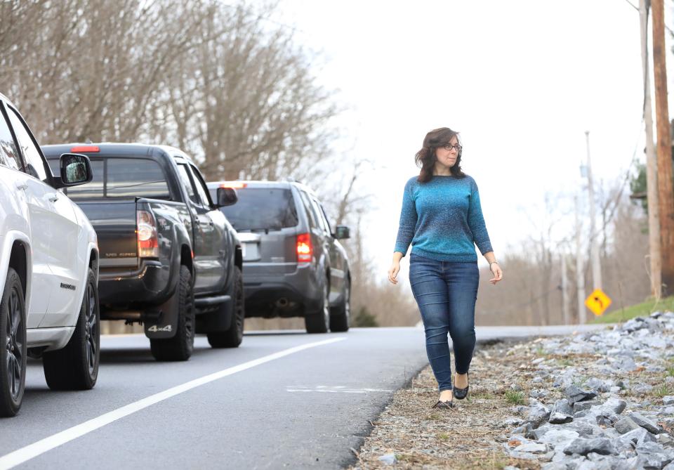 Lia-Marie Henry walks along the shoulder at the intersection of Maloney Road and Noxon Road in LaGrange on March 15, 2024. Henry was rear ended by a Dutchess County Sheriff's deputy, which resulted in her car being totaled.