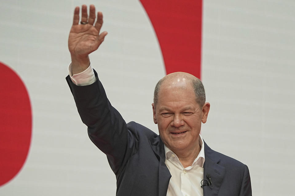 Olaf Scholz, SPD Chancellor-designate waves at the SPD party conference at Willy Brandt House in Berlin, Germany, Saturday, Dec.4, 2021. Delegates vote on a coalition agreement with the FDP and Bündnis90/Die Grünen to form a new federal government. (Michael Kappeler/dpa via AP)
