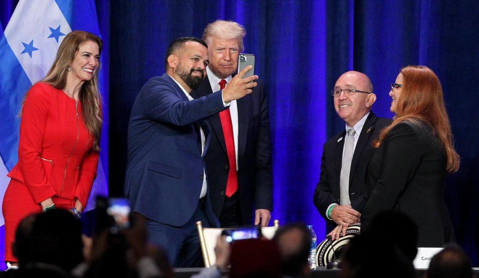 President Donald Trump poses for a picture with, from left, Nicaraguan Karla Salvatierra, Puerto Rican Hiram Turrull, Colombian Fabio Andrade and Cuban Carolina Ferreiro, as he meets with a group of South Florida community members during the Latinos for Trump roundtable at the Trump National Doral in Doral, Florida, on Friday, September 25, 2020.