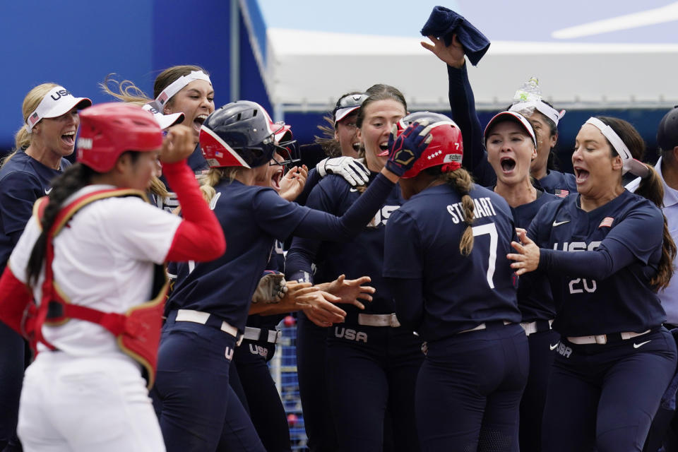 United States' Kelsey Stewart (7) is greeted at the plate by her teammates following her game winning home run against Japan in the seventh inning of a softball game at the 2020 Summer Olympics, Monday, July 26, 2021, in Yokohama, Japan. (AP Photo/Sue Ogrocki)