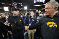 Michigan head coach Jim Harbaugh, left, greets Iowa head coach Kirk Ferentz at the end of the Big Ten championship NCAA college football game, Saturday, Dec. 4, 2021, in Indianapolis. Michigan won 42-3. (AP Photo/AJ Mast)