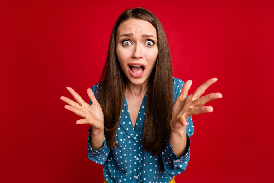 Close-up portrait of attractive desperate puzzled girl bad news panic isolated bright red color background.