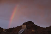 FILE - A rainbow appears behind water pipes conveying water from the Colorado River at Gene Camp, a facility operated by the Metropolitan Water District of Southern California, near Parker Dam, Calif. The U.S. Bureau of Reclamation is expected to publish hydrology projections on Tuesday, Aug. 16, 2022, that will trigger agreed-upon cuts to states that rely on the river. (AP Photo/Jae C. Hong, File)