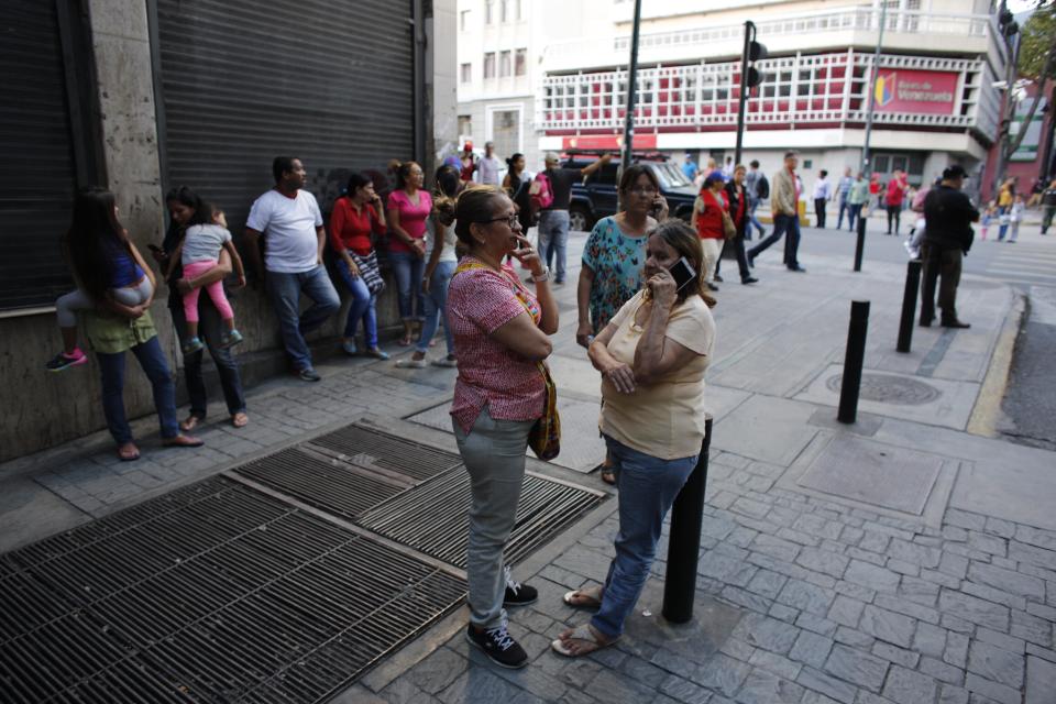 Residentes se detienen en la calle luego de que un fuerte sismo sacudiera el este de Venezuela y provocara la evacuación de edificios en Caracas, Venezuela, el martes 21 de agosto de 2018. (AP Foto/Ariana Cubillos)