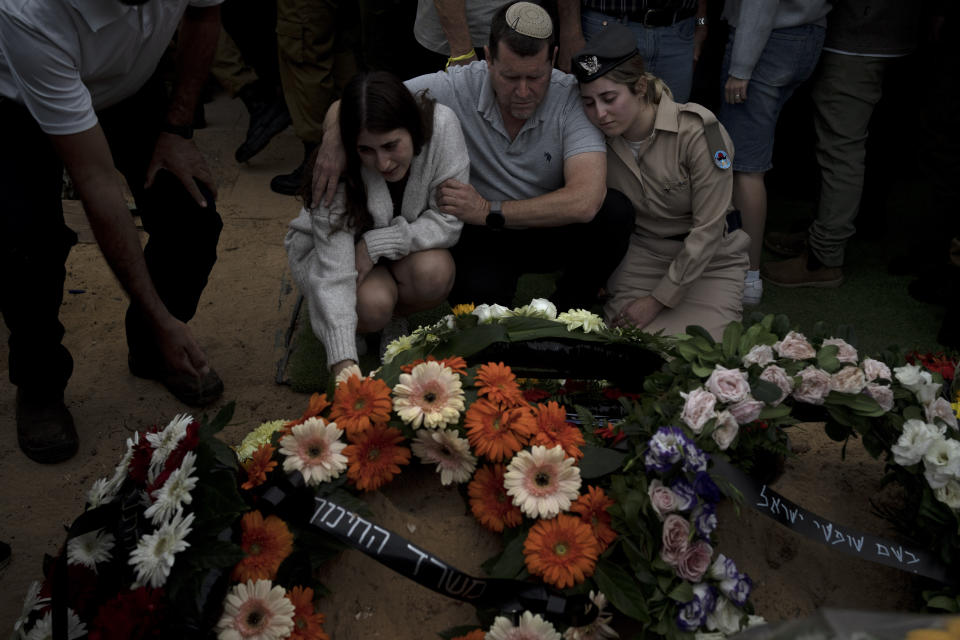 Naama Doplet, left, is comforted at the grave of her, Israeli Army Capt. Kfir Franco, who was killed in combat in the Gaza Strip, during his funeral at Mt. Herzl military cemetery in Jerusalem, Thursday, Nov. 16, 2023. (AP Photo/Maya Alleruzzo)