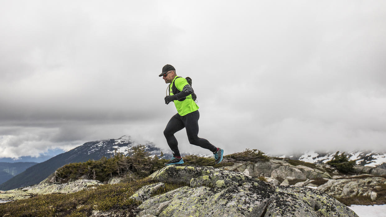  A man runs across a rocky mountaintop. 