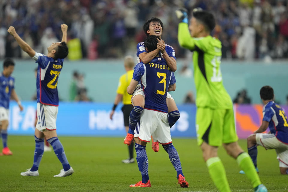 Japan players celebrate at the end of the World Cup group E soccer match between Japan and Spain, at the Khalifa International Stadium in Doha, Qatar, Thursday, Dec. 1, 2022. Japan won 2-1. (AP Photo/Julio Cortez)