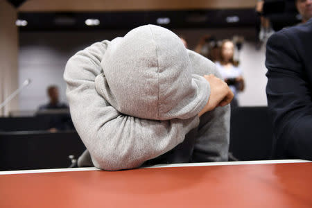 The 18-year-old Moroccan Mohamed Bakier, covers his face during the initial remand hearing of suspects of killing two people and attempting to kill eight others with terrorist intent in Turku last week, at the Southwest Finland District Court in Turku, Finland, August 22, 2017. LEHTIKUVA / Martti Kainulainen via REUTERS