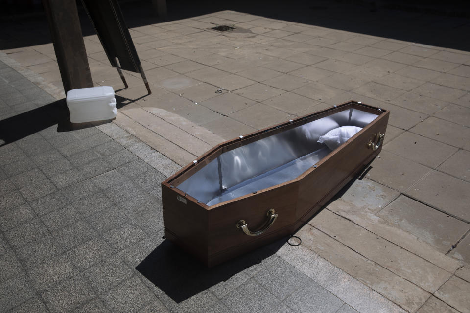 An open coffin lies on the ground at a special morgue for COVID-19 victims in the central Israeli city of Holon, near Tel Aviv, Wednesday, Sept. 23, 2020. With Israel facing one of the world's worst outbreaks, burial workers have been forced to wear protective gear and take other safety measures as they cope with a growing number of coronavirus-related deaths. (AP Photo/Oded Balilty)