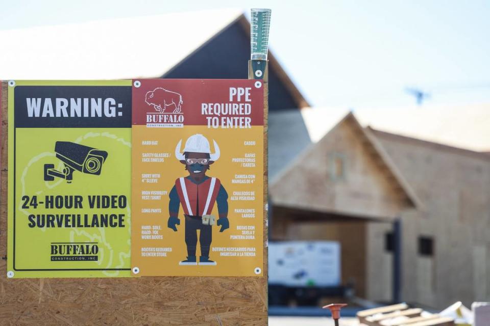 Un cartel que detalla el equipo de seguridad que todos los trabajadores de la construcción deben usar en el lugar está a la vista en un sitio de construcción de Charlotte.