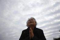 A family member of a missing passenger from the capsized passenger ship Sewol prays while waiting for news from rescue and salvage teams, at a port in Jindo April 22, 2014. REUTERS/Kim Hong-Ji