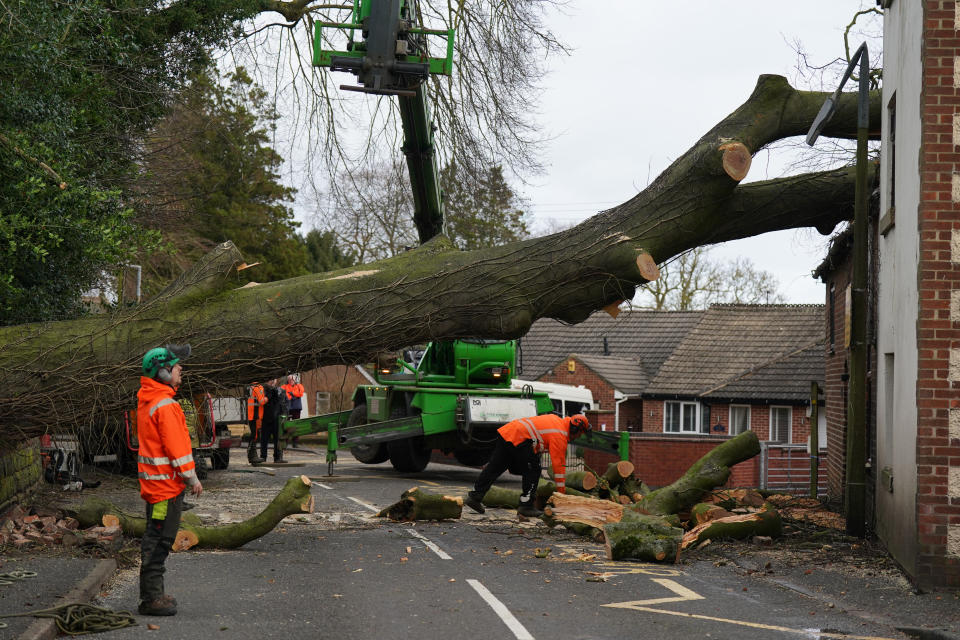 Workmen remove a fallen tree which has damaged the roof of a house in the village of Stanley in Derbyshire during high winds from Storm Pia, which is expected to cause disruption in parts of Scotland, the north of England and Northern Ireland. Picture date: Thursday December 21, 2023. PA Photo. See PA story WEATHER Wind. Photo credit should read: Jacob King/PA Wire 
