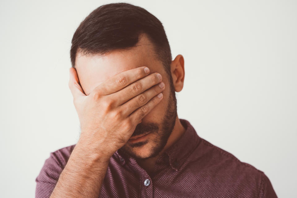 Man covering his face.