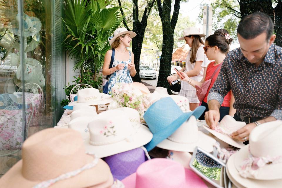 Tinsley Merrill, left, sells Corazon Playero hats during the opening of the LoveShackFancy in Coconut Grove.