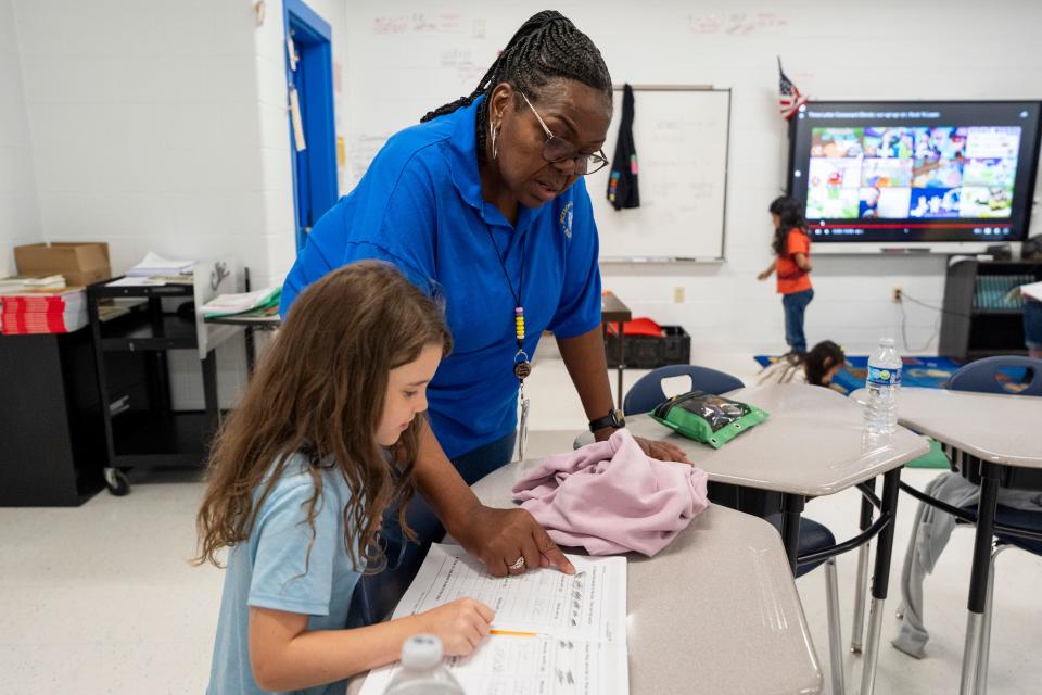 Dr. Deborah Anderson, the instructional facilitator at Jackson Elementary, speaks with rising second-grader Bryleigh about a reading worksheet during the Memphis Shelby County Schools Summer Learning Academy in Memphis, Tenn., on Monday, July 8, 2024.