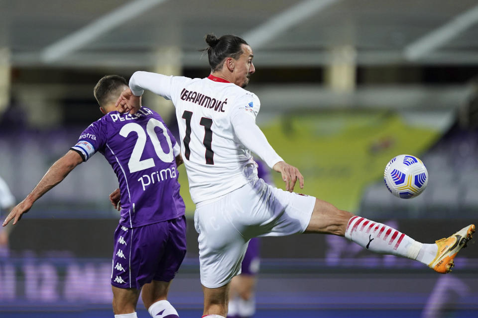 AC Milan's Zlatan Ibrahimovic vies for the ball with Fiorentina's German Pezzella, right, during a Serie A soccer match between Fiorentina and AC Milan, in Florence's Artemio Franchi stadium, Italy, Sunday, March 21, 2021. (Spada/LaPresse via AP)