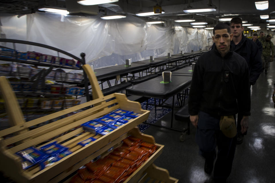 Sailors of the USS Bataan make their way through one of the ship's four mess decks on Monday, March 20, 2023 at Norfolk Naval Station in Norfolk, Va. The four mess decks are separated by rank: one for lower enlisted, petty officers, officers, and command staff. (AP Photo/John C. Clark)