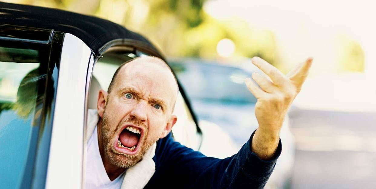 enraged male driver shouts and gestures threateningly