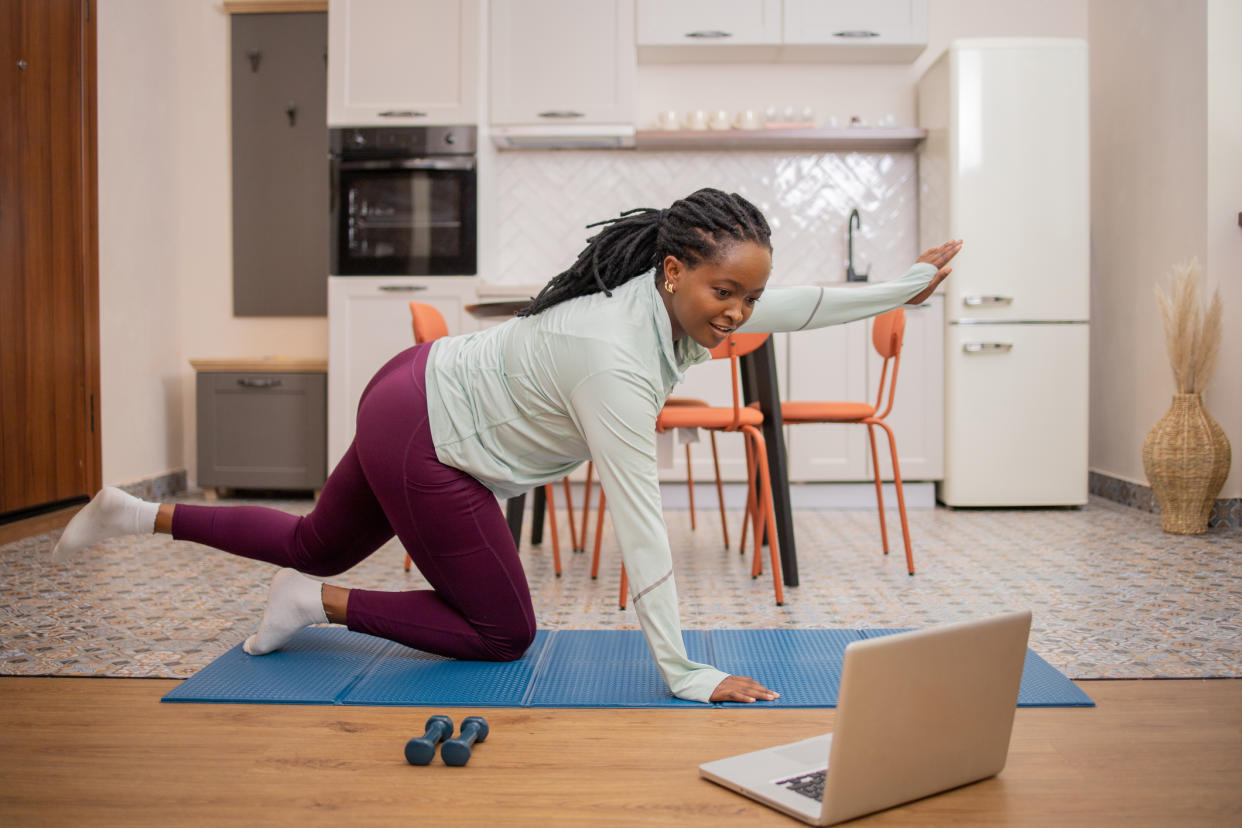  Woman doing workout at home in kitchen 