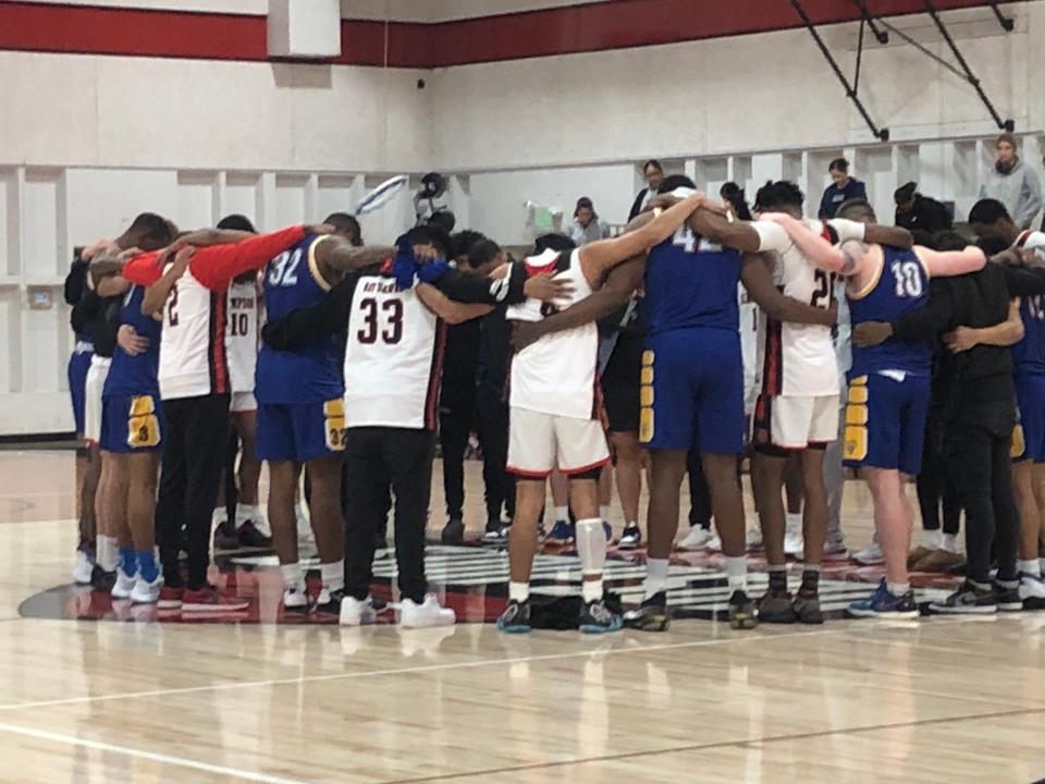 Basketball players from Simpson University and Westcliff University join in a prayer circle after Red Hawks guard was injured during a play on Saturday, Feb. 4, 2023.