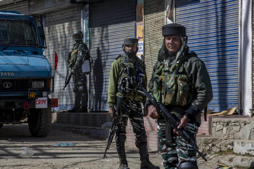 Indian paramilitary soldiers stand guard during a gunbattle between Indian soldiers and suspected militants in Shopian, south of Srinagar, Indian controlled Kashmir, Friday, April 9, 2021. Seven suspected militants were killed and four soldiers wounded in two separate gunfights in Indian-controlled Kashmir, officials said Friday, triggering anti-India protests and clashes in the disputed region. (AP Photo/ Dar Yasin)