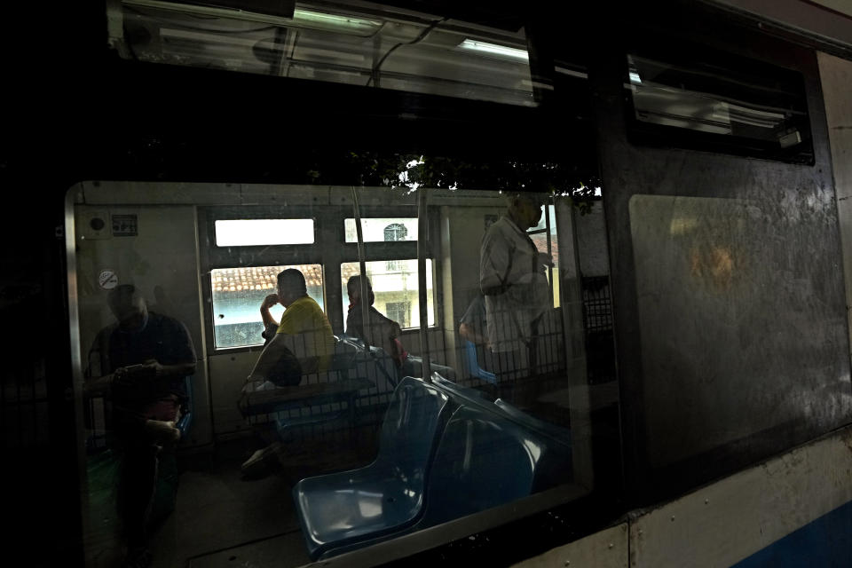 People wait inside a railroad car at the train station in the Bom Parto neighborhood, in Maceio, Alagoas state, Brazil, Tuesday, March 8, 2022. Residents of the Bom Parto neighborhood have been forced to leave their homes because of geological problems arising from mining activities that have created the threat of ground subsidence, forcing the evacuation of about 55 thousand persons from their homes. (AP Photo/Eraldo Peres)