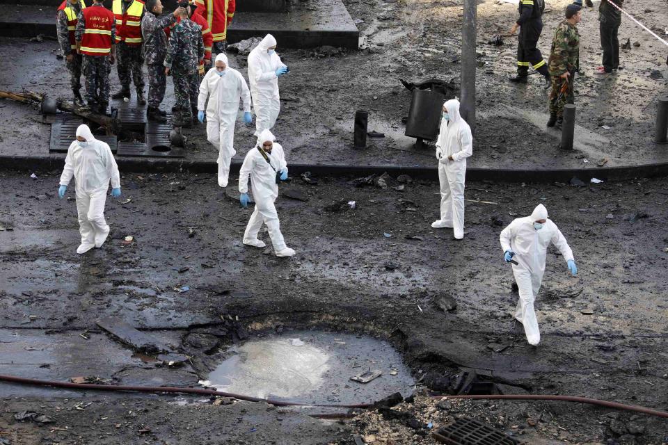 Forensic inspectors examine the site of an explosion in downtown Beirut December 27, 2013. Former Lebanese minister Mohamad Chatah, who opposed Syrian President Bashar al-Assad, was killed in the massive bomb blast which one of his political allies blamed on Lebanon's Shi'ite Hezbollah militia. (REUTERS/Mohamed Azakir)