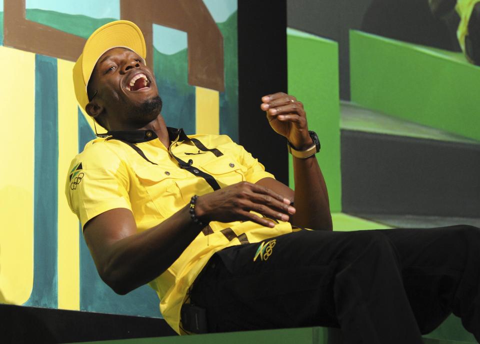 Jamaican sprinter Usain Bolt laughs during a team news conference in east London, July 26, 2012. REUTERS/Paul Hackett